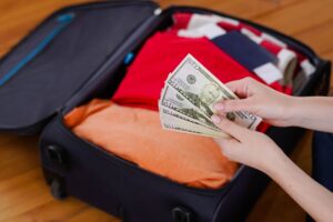 Female hands counting dollars on suitcase | How much is parking in miami cruise port