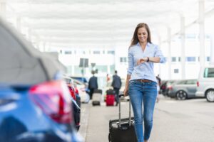 Woman walking with suitcase in parking lot | Parking in Miami Cruise Port